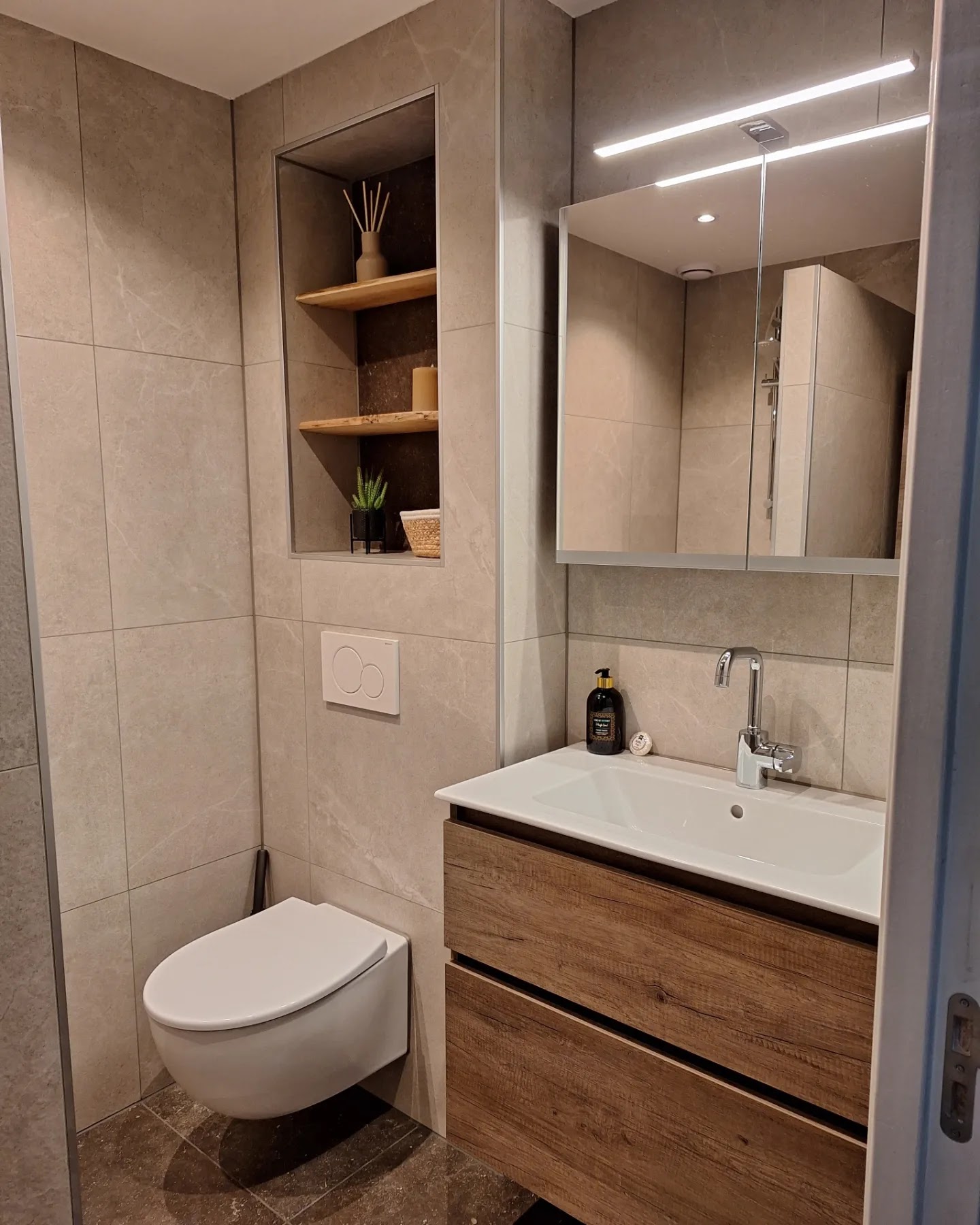 Afgewerkte badkamer met wandmeubel en een nis in de wand
