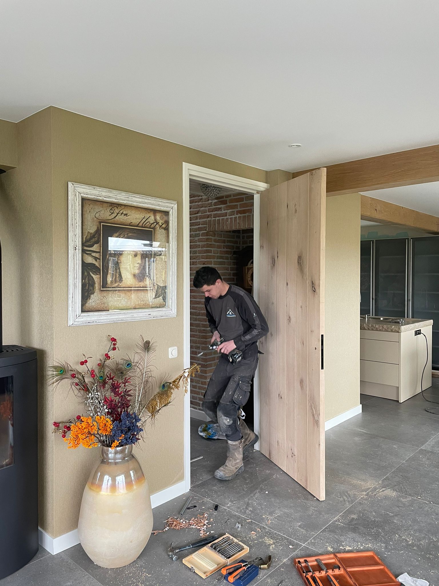 Timmerman plaatst een eiken deur in een woonkamer