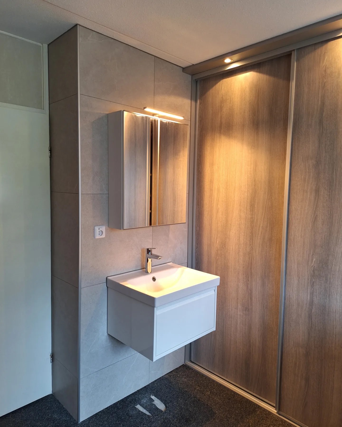 Badkamer met hangend wastafelmeubel en houten schuifwand